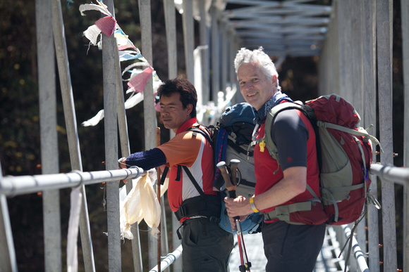Guide Pasang Sherpa and Mark crossing a bridge on the way to Beding